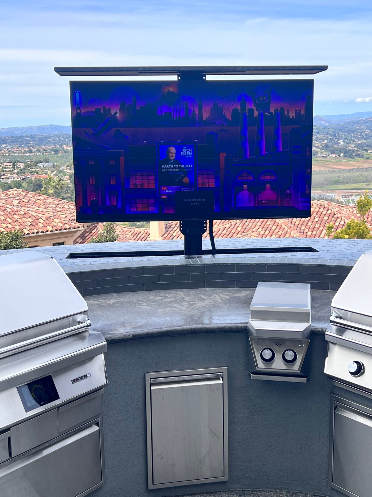 Outdoor kitchen with built-in grills and pop-up TV by Panjia Outdoors in Poway