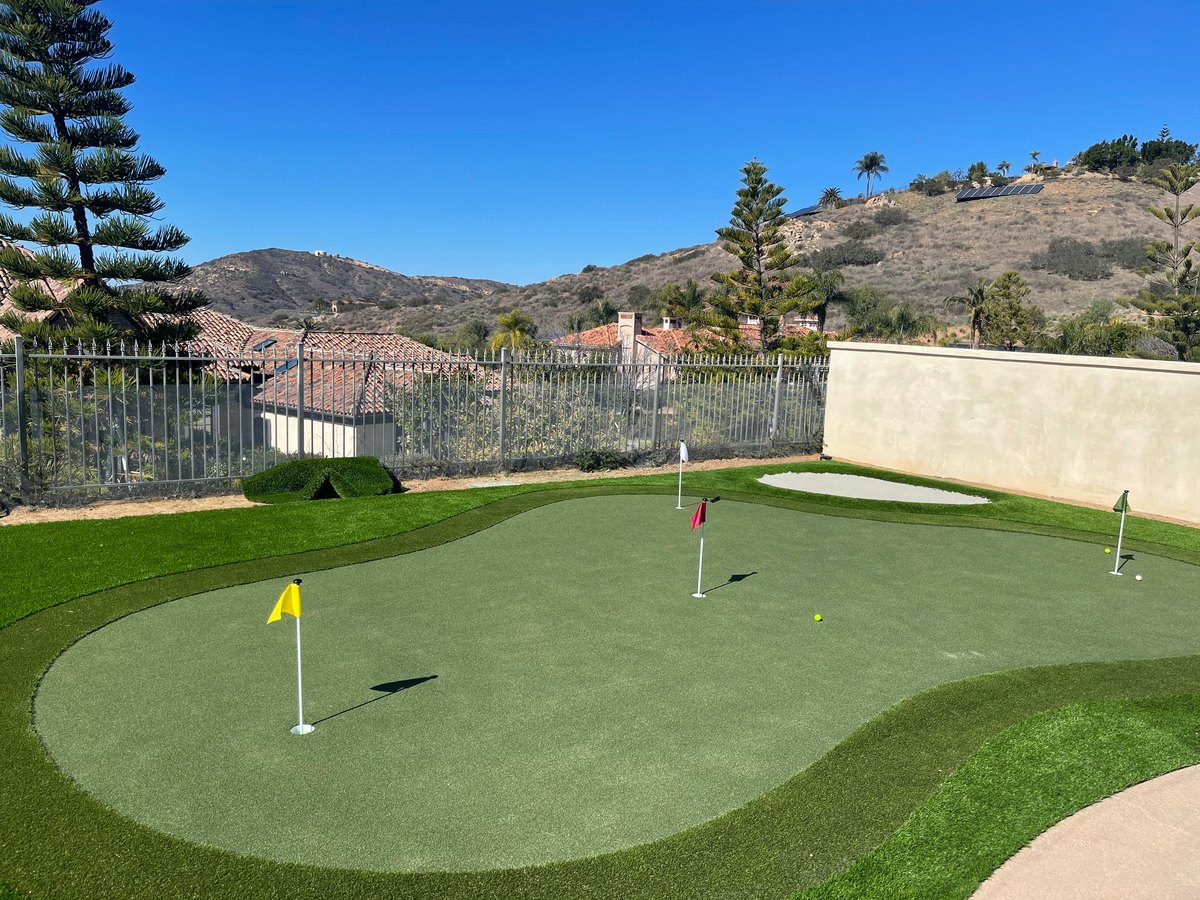 Sloped backyard putting green with a view by Panjia Outdoors in San Diego County