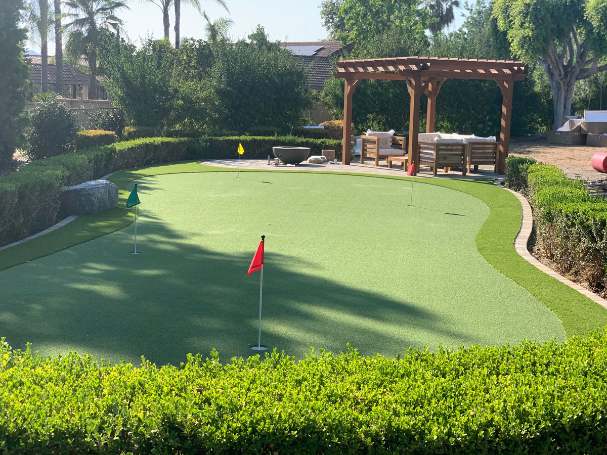 Multi-hole backyard putting green with flags by Panjia Outdoors in San Diego County