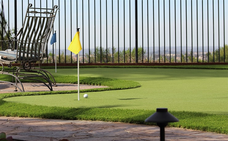 Backyard putting green with flag and hillside view by Panjia Outdoors in North County San Diego